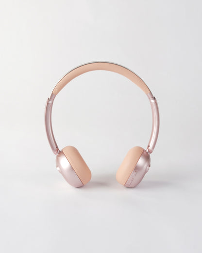 Frontal view of the höhen aura mini headphones in pink featuring a sleek metallic pink finish and minimalist control buttons