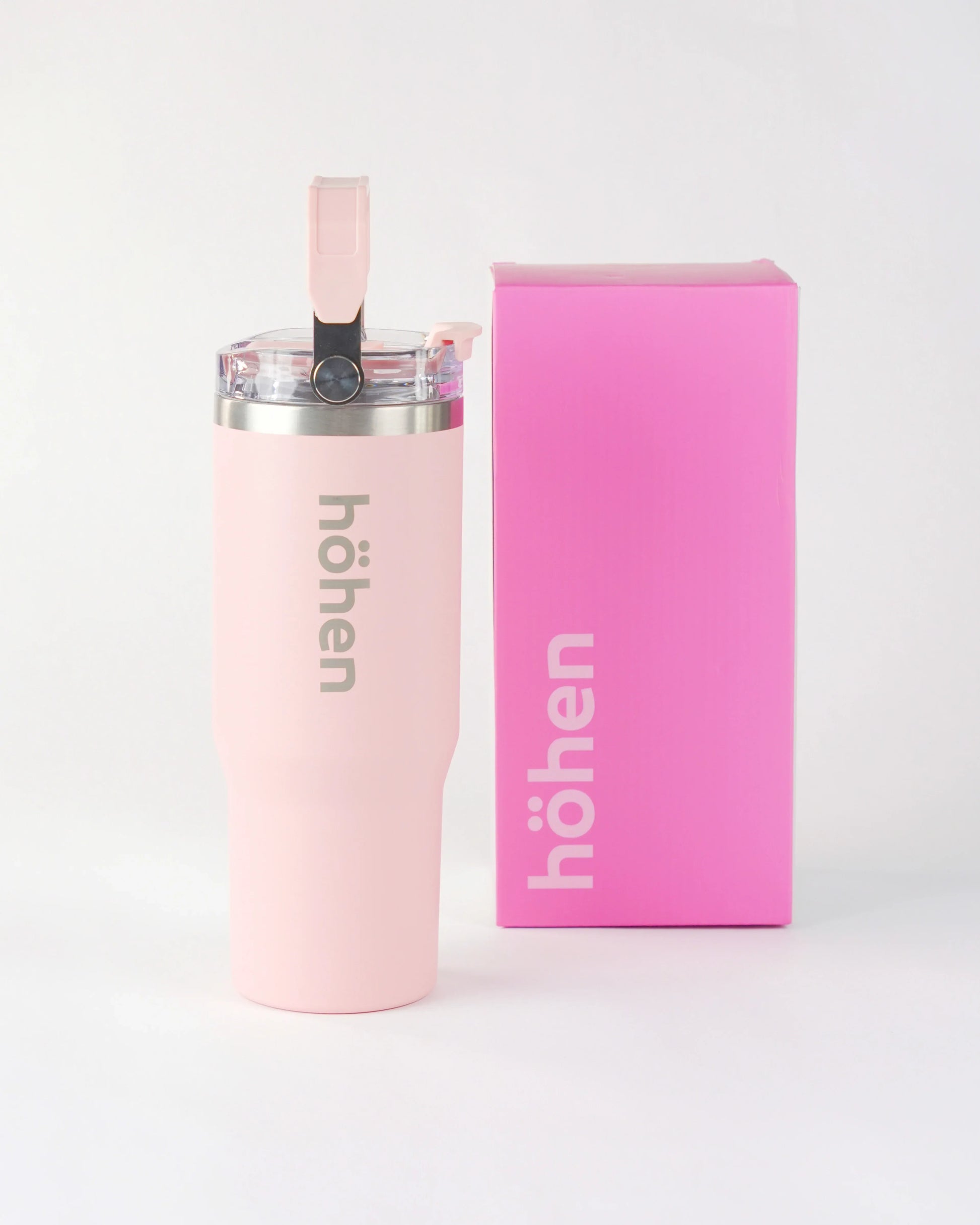 The pink höhen Essential stainless steel tumbler standing next to its official Aurora Pink branded box, featuring the vertical Canaro typeface logo