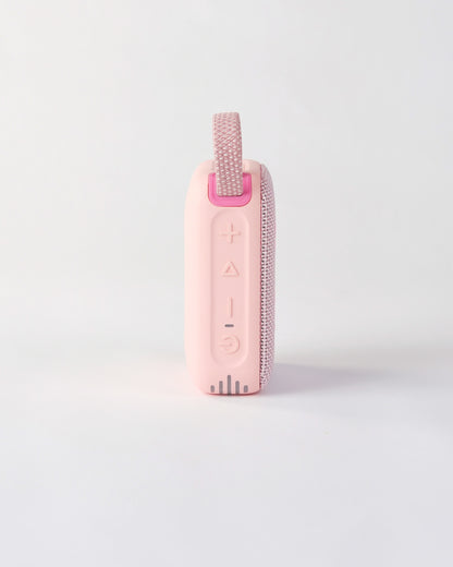 Side view of the pink höhen move wireless speaker highlighting the tactile control buttons for power, volume, and playback