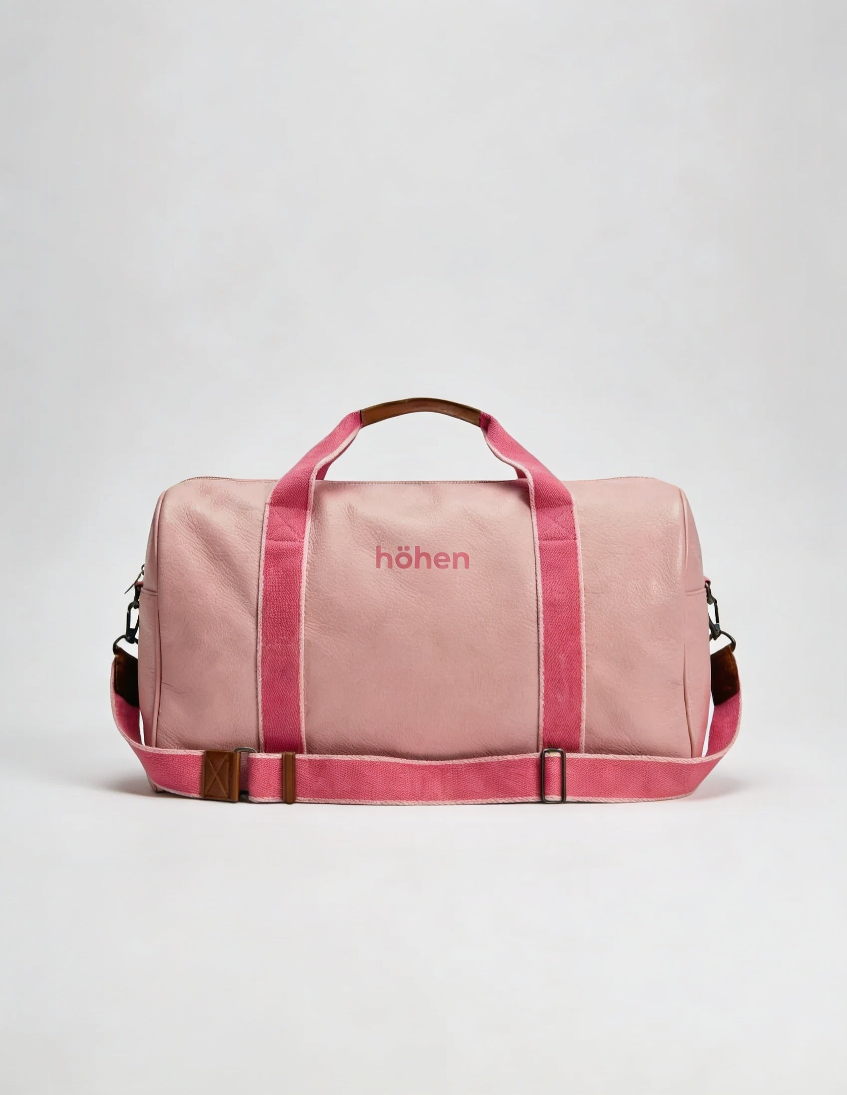 The höhen One pink bag with fuchsia straps and Höhen logo, front view on white background, women’s gym and travel bag.