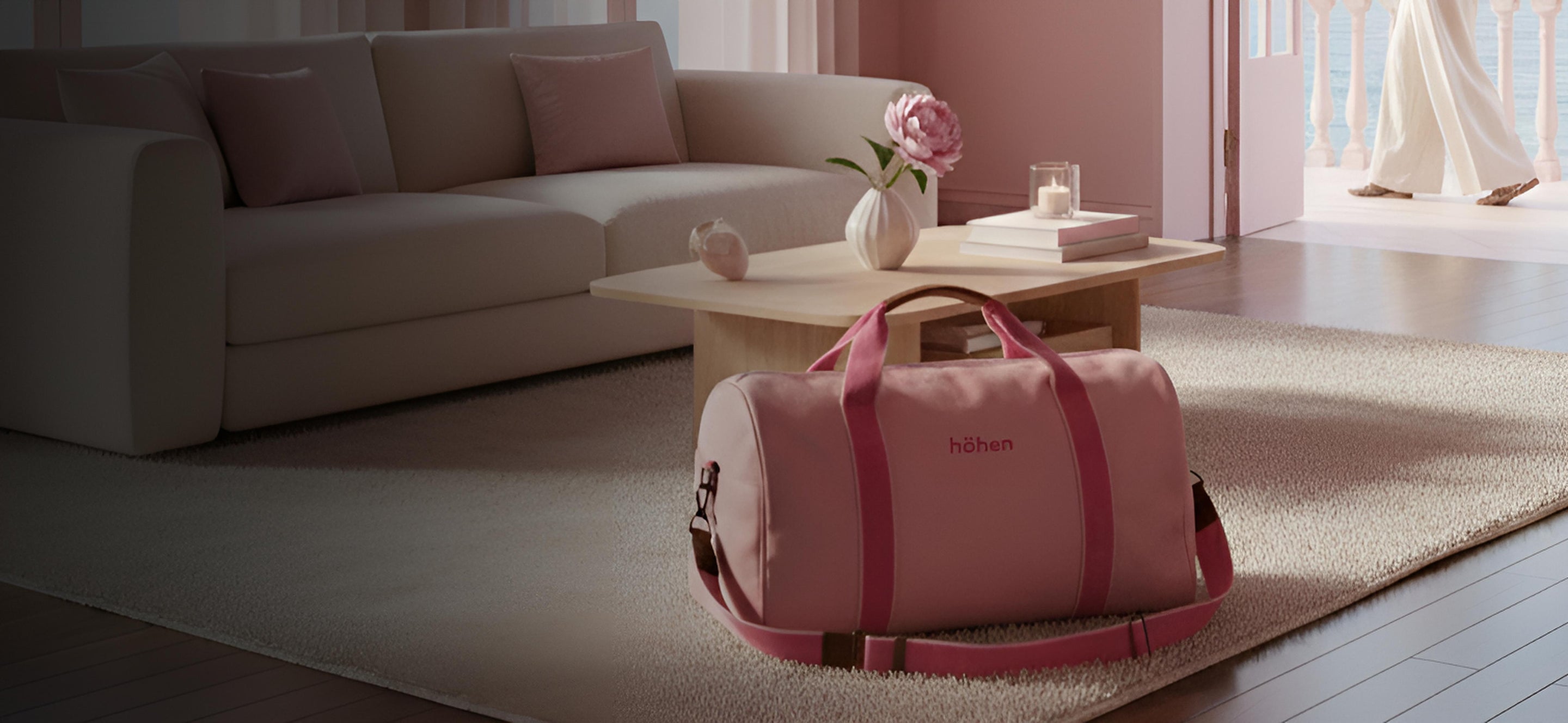 The höhen one travel bag in pink placed in a minimalist living room, ideal for weekend getaways.