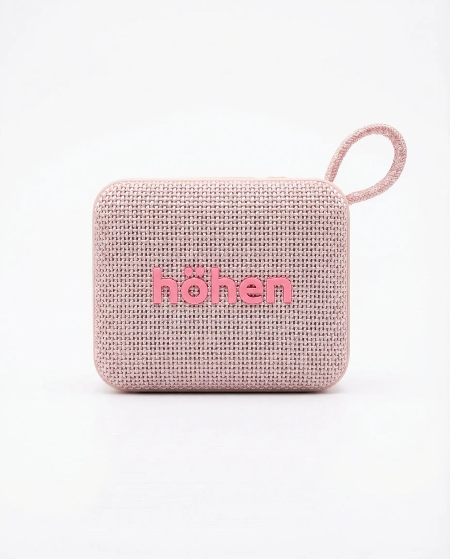 Parlante Bluetooth Höhen Move color rosa con acabado en tela, diseño compacto y correa de transporte.
