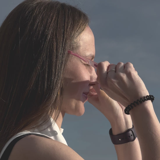 lose-up of a woman smiling and wearing pink höhen aero sports sunglasses with iridescent lenses outdoor