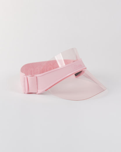 Side view of a pink höhen soleil women’s sports visor with a clear pink transparent shield and adjustable elastic band on a white background.